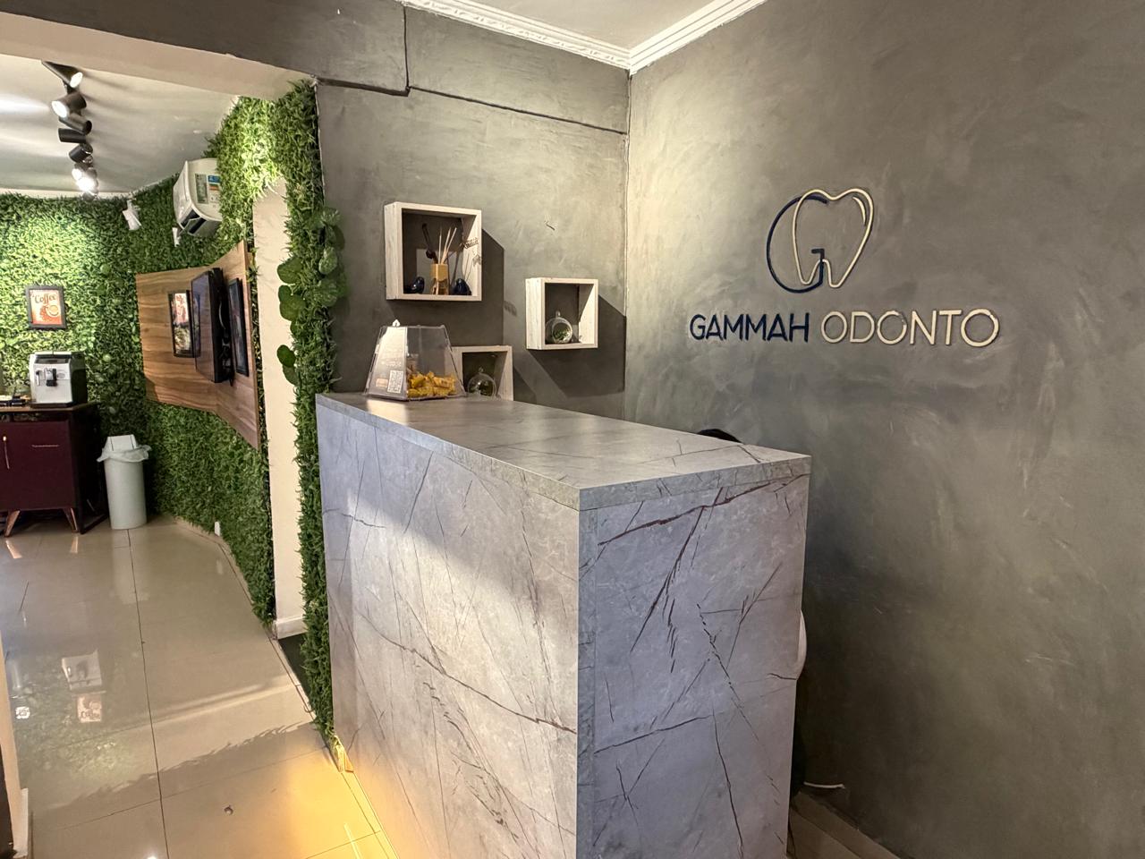Recepção da Gammah Odonto, com balcão e identificação do consultório